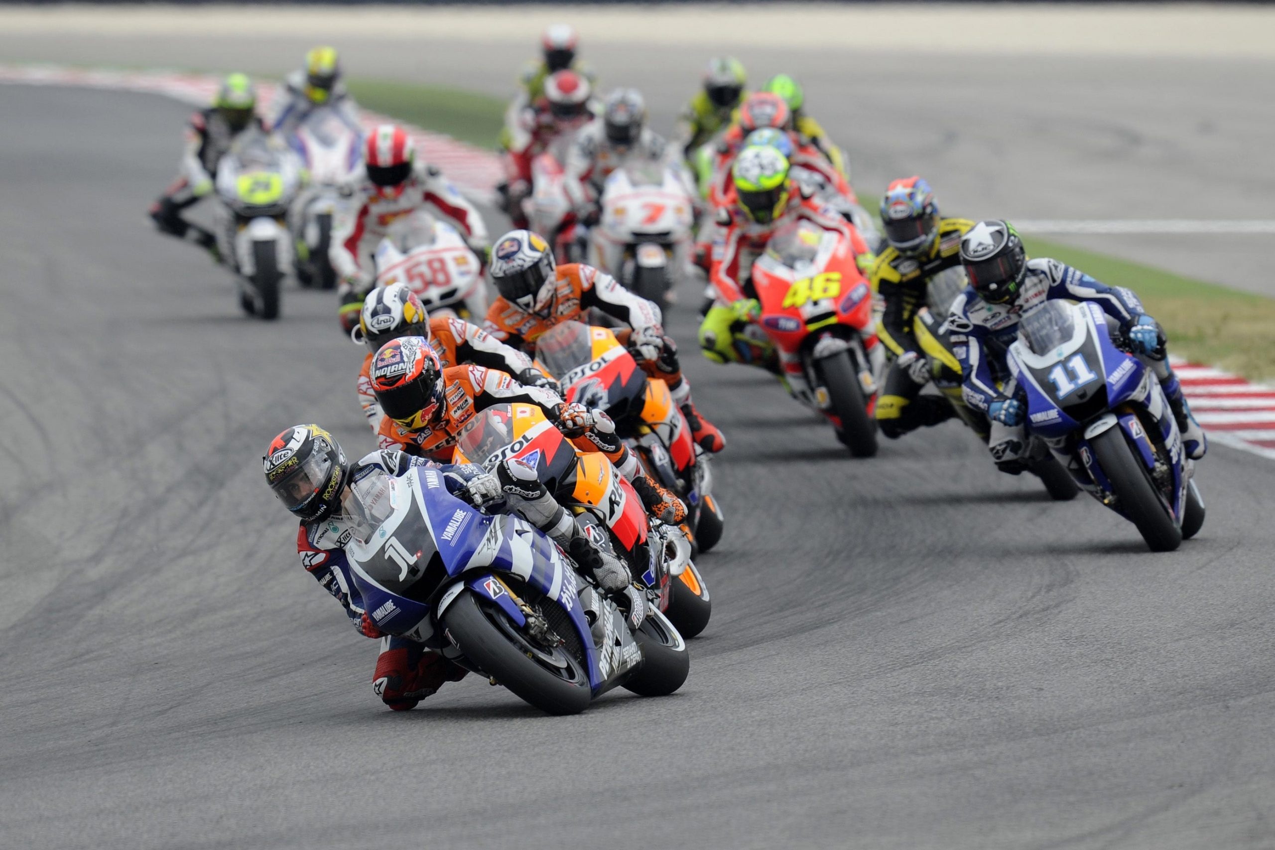 Jorge Lorenzo number 1, Marco Simoncelli number 58, Valentino Rossi number 46, Ben Spies number 11, MotoGP pack through corner, HD Desktop wallpaper