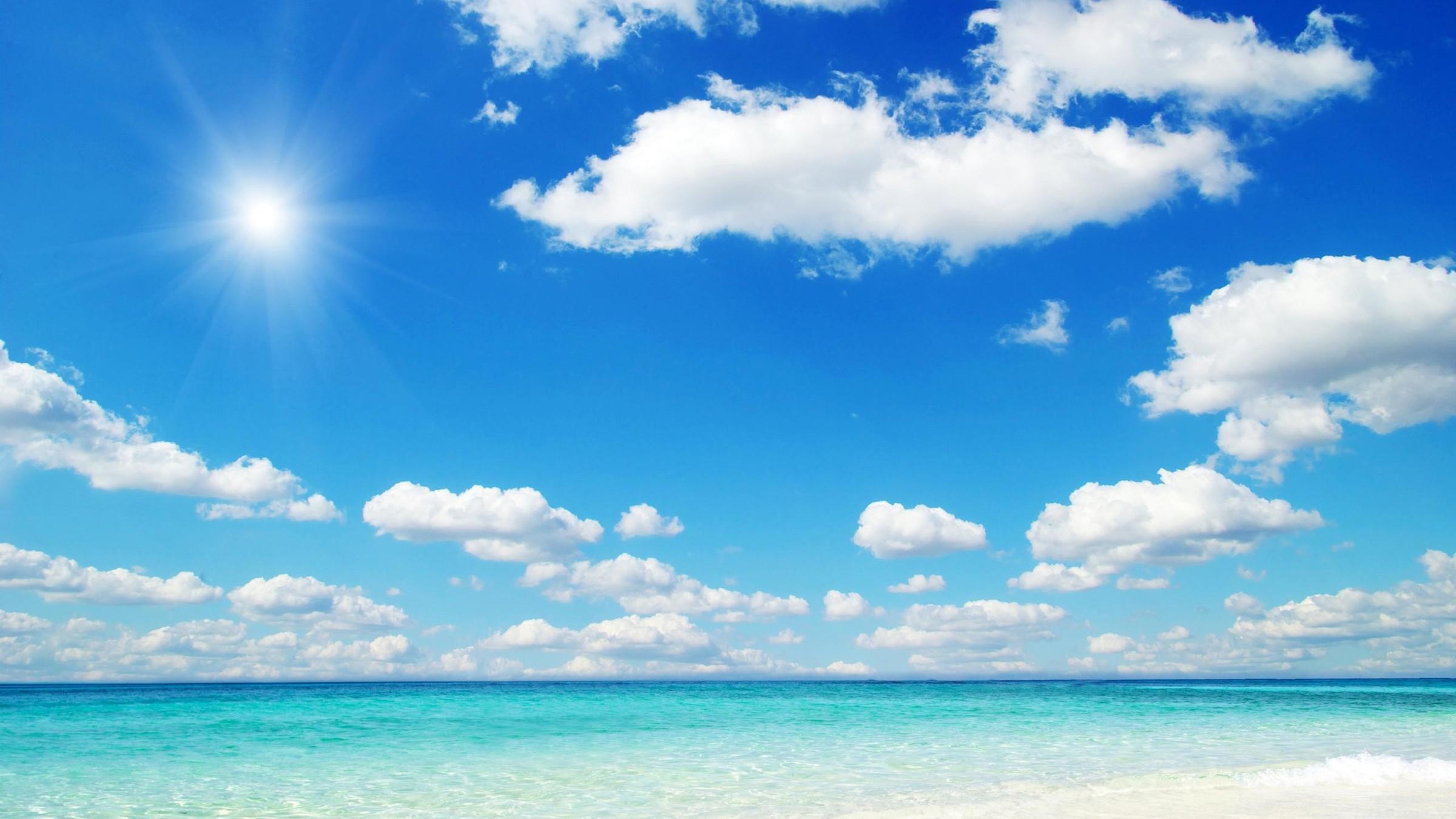 Bright midday sun flare, Fluffy white cumulus clouds, Turquoise ocean beach shoreline, HD Desktop wallpaper