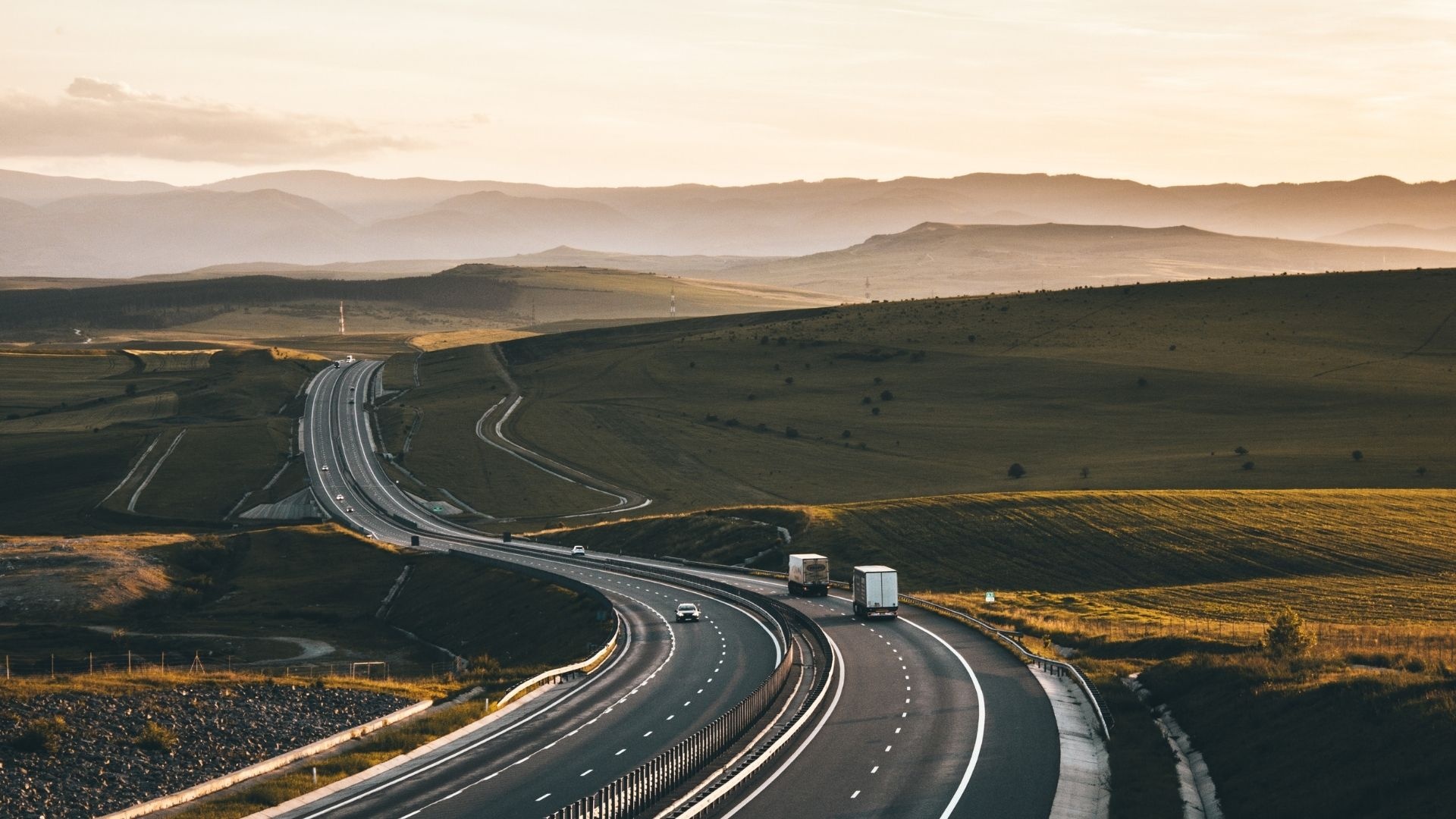 curving asphalt highway, freight semi trucks, golden hour rolling hills, Full HD Desktop wallpaper