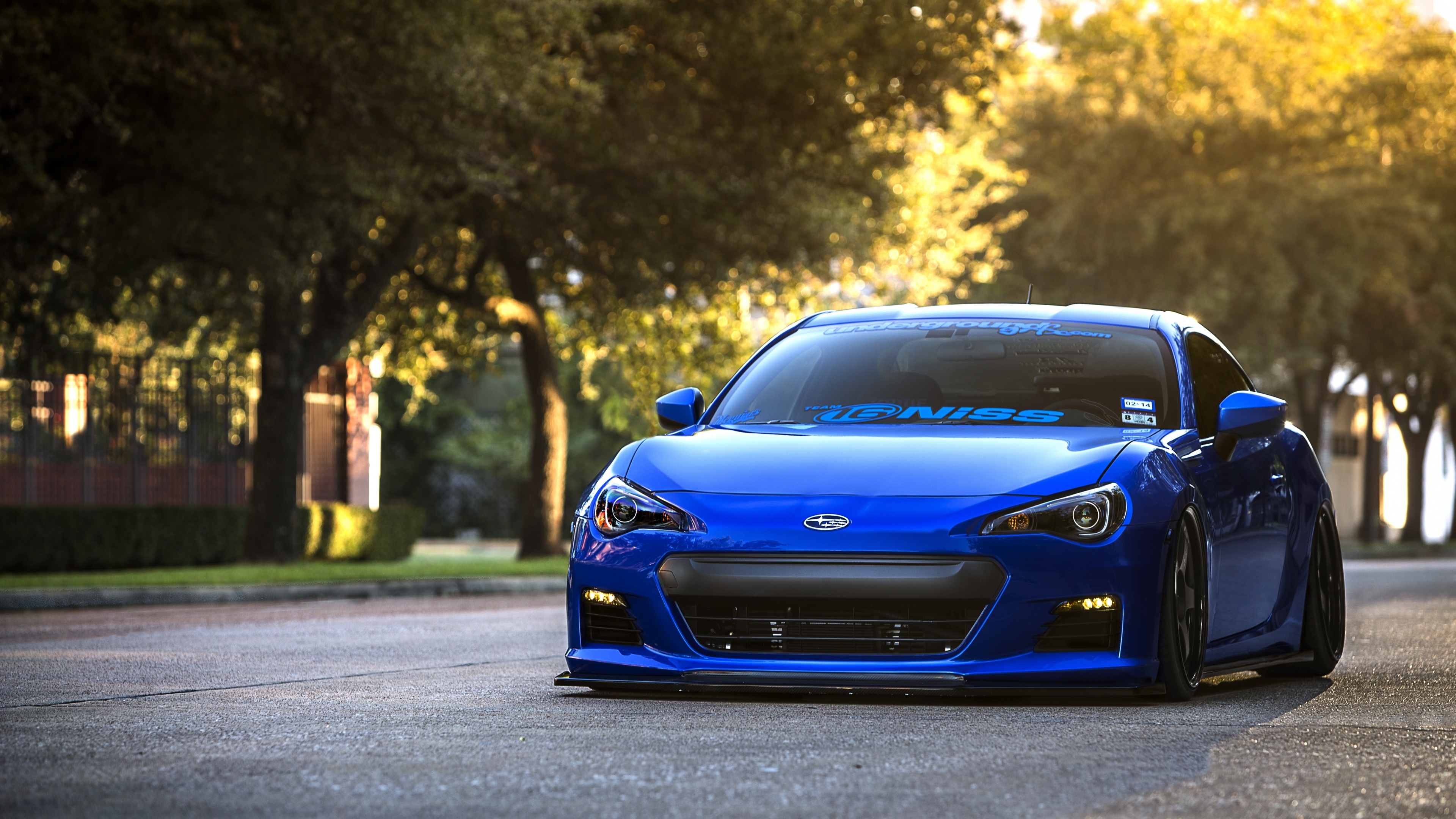 blue Subaru BRZ, TEAM IGNISS decal, tree-lined sunlit street, 4K Desktop wallpaper