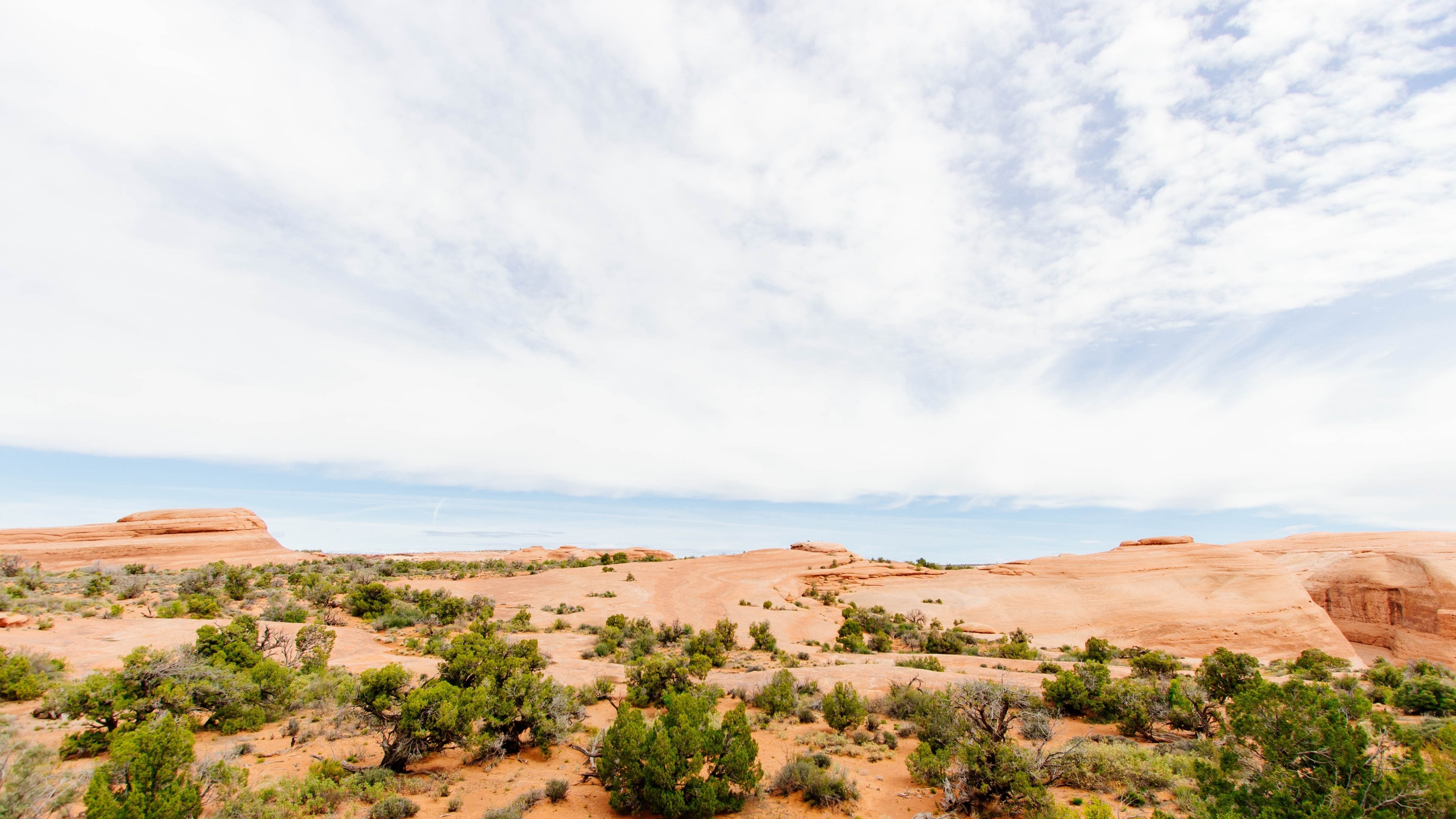 Sandstone rock formation, Desert juniper scrub, Bright wispy sky, 4K Desktop wallpaper