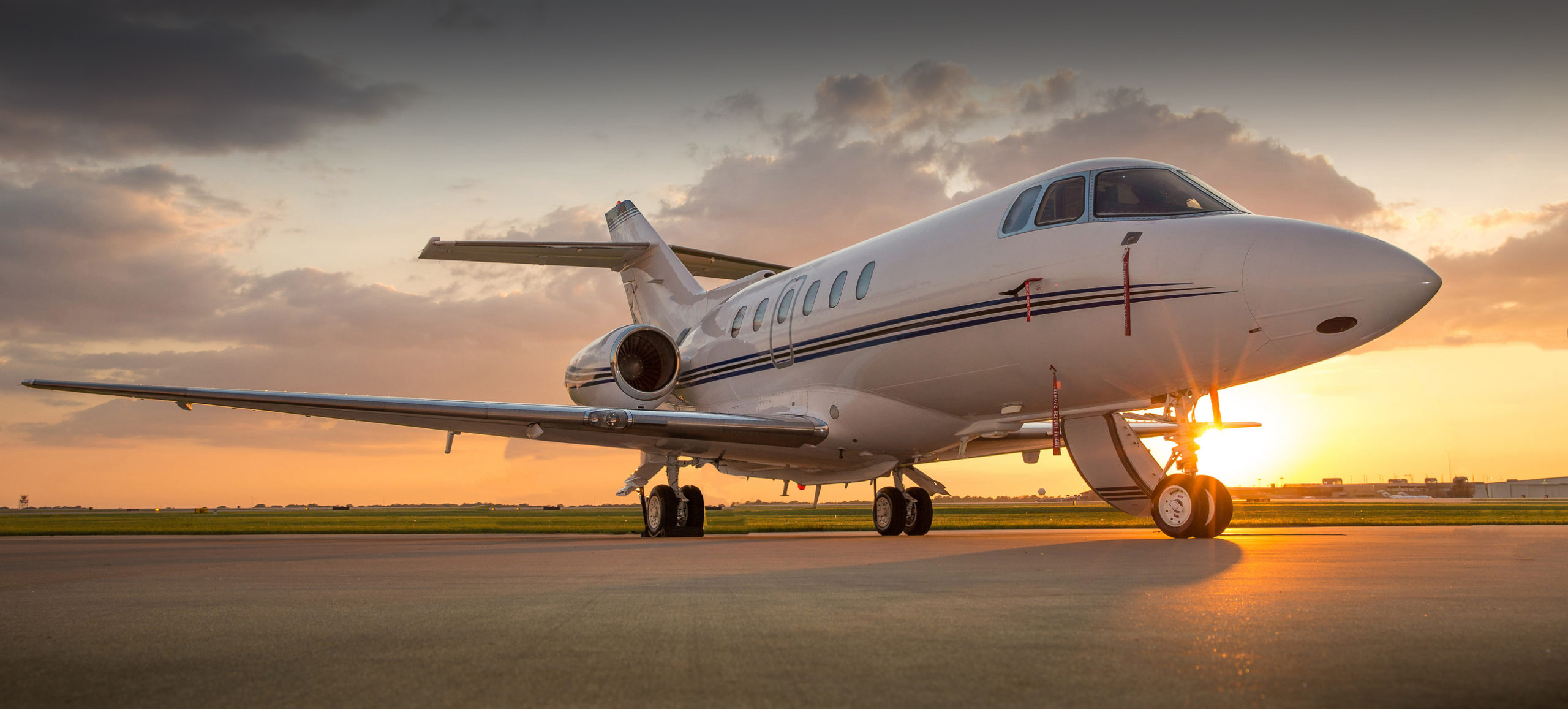 Hawker 800XP business jet, Airport tarmac at sunset, Golden hour glow, Dual Screen Desktop wallpaper