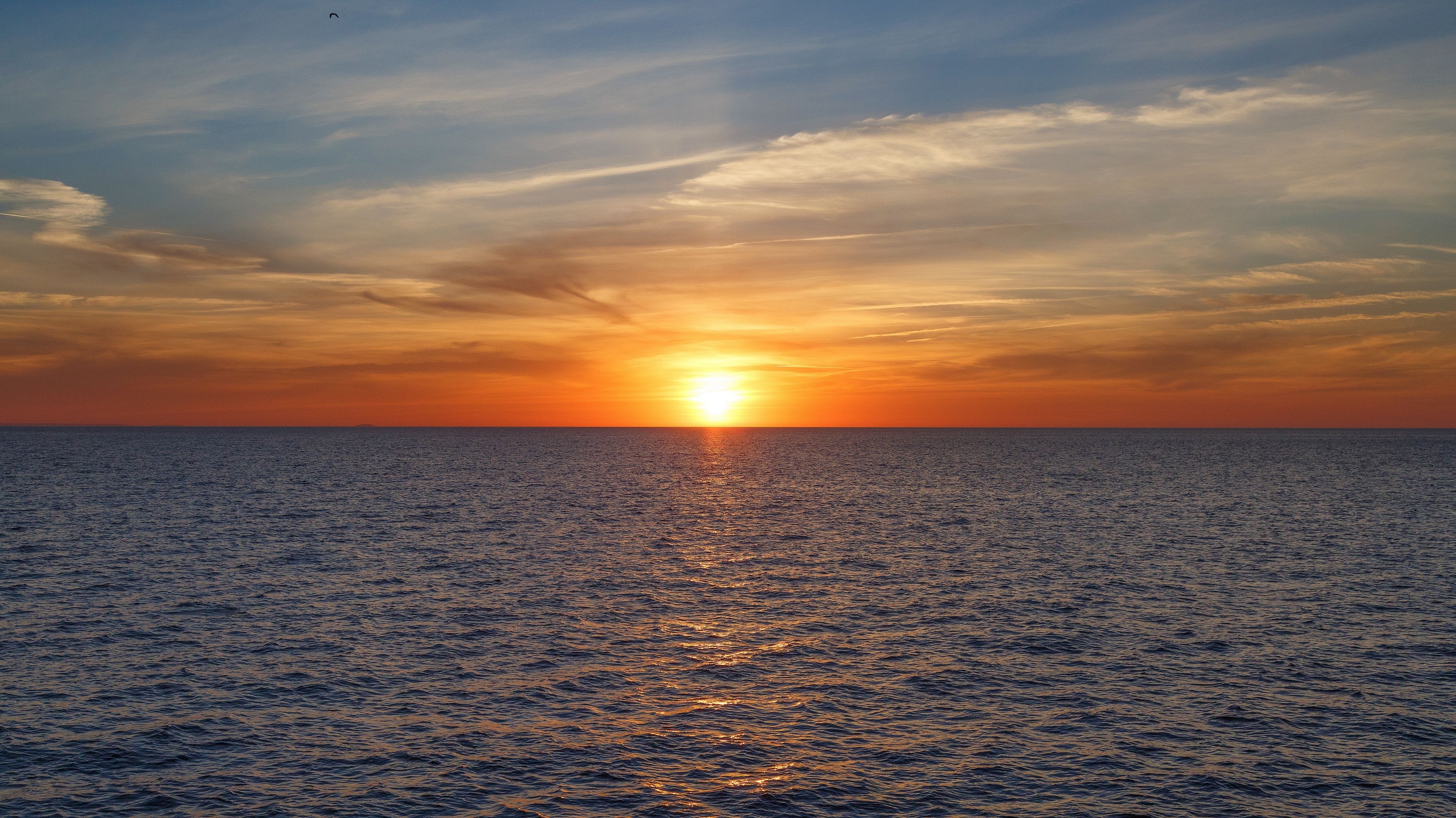 Setting sun on horizon, Golden ocean water reflection, Wispy twilight clouds, 4K Desktop wallpaper
