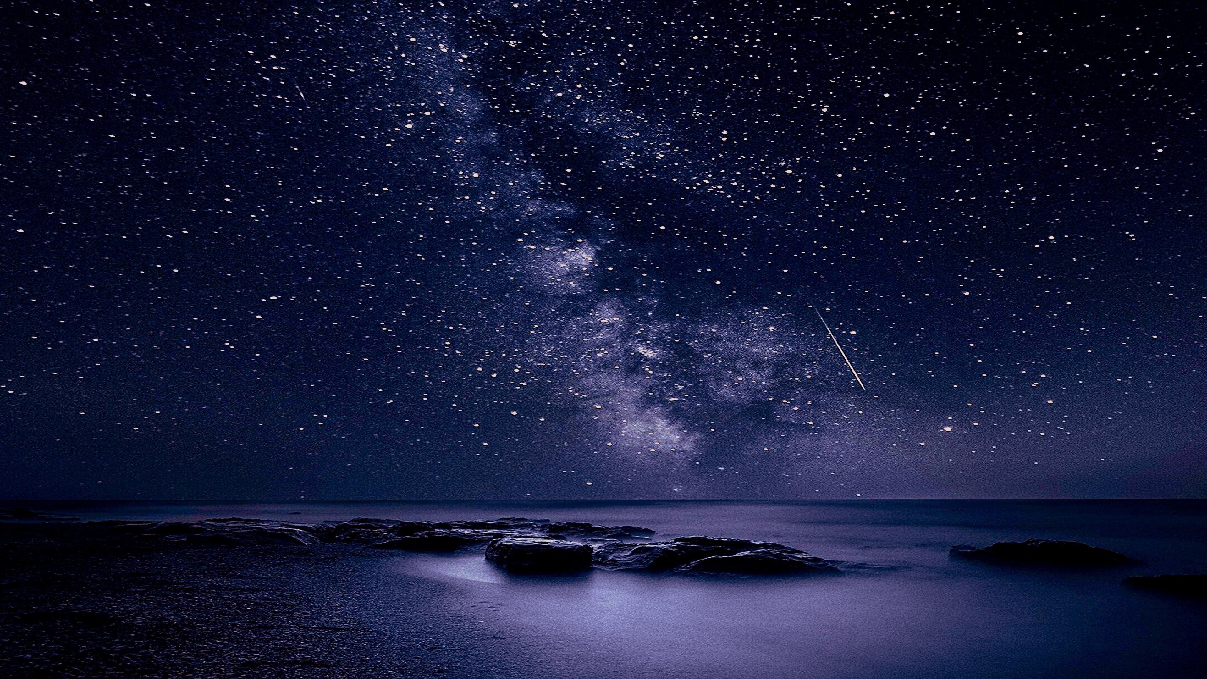 Milky Way galaxy, shooting star streak, rocky ocean shoreline, 4K Desktop wallpaper