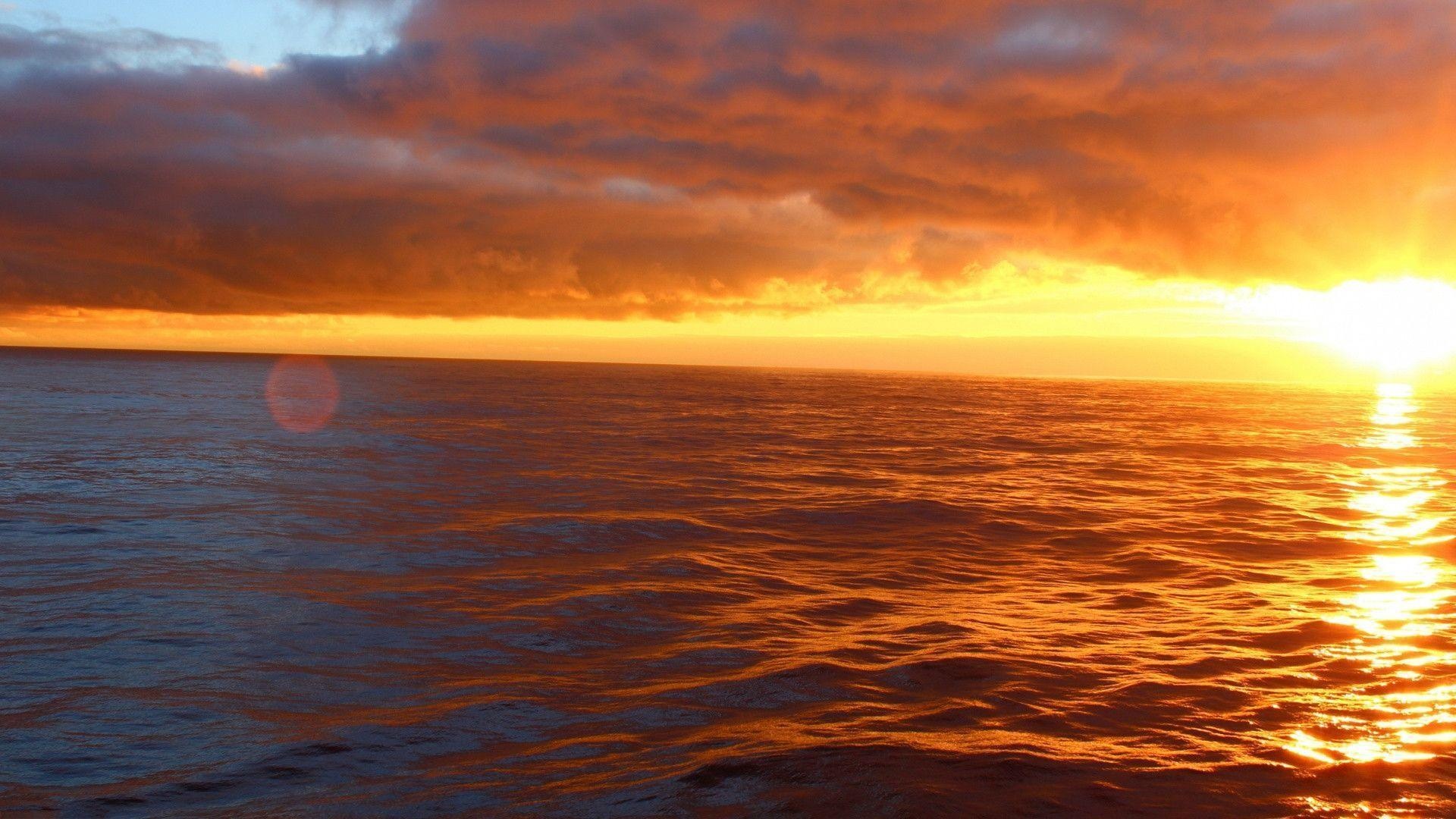 Golden sunset ocean horizon, Dramatic orange evening clouds, Sunlit sea surface reflection, Full HD Desktop wallpaper
