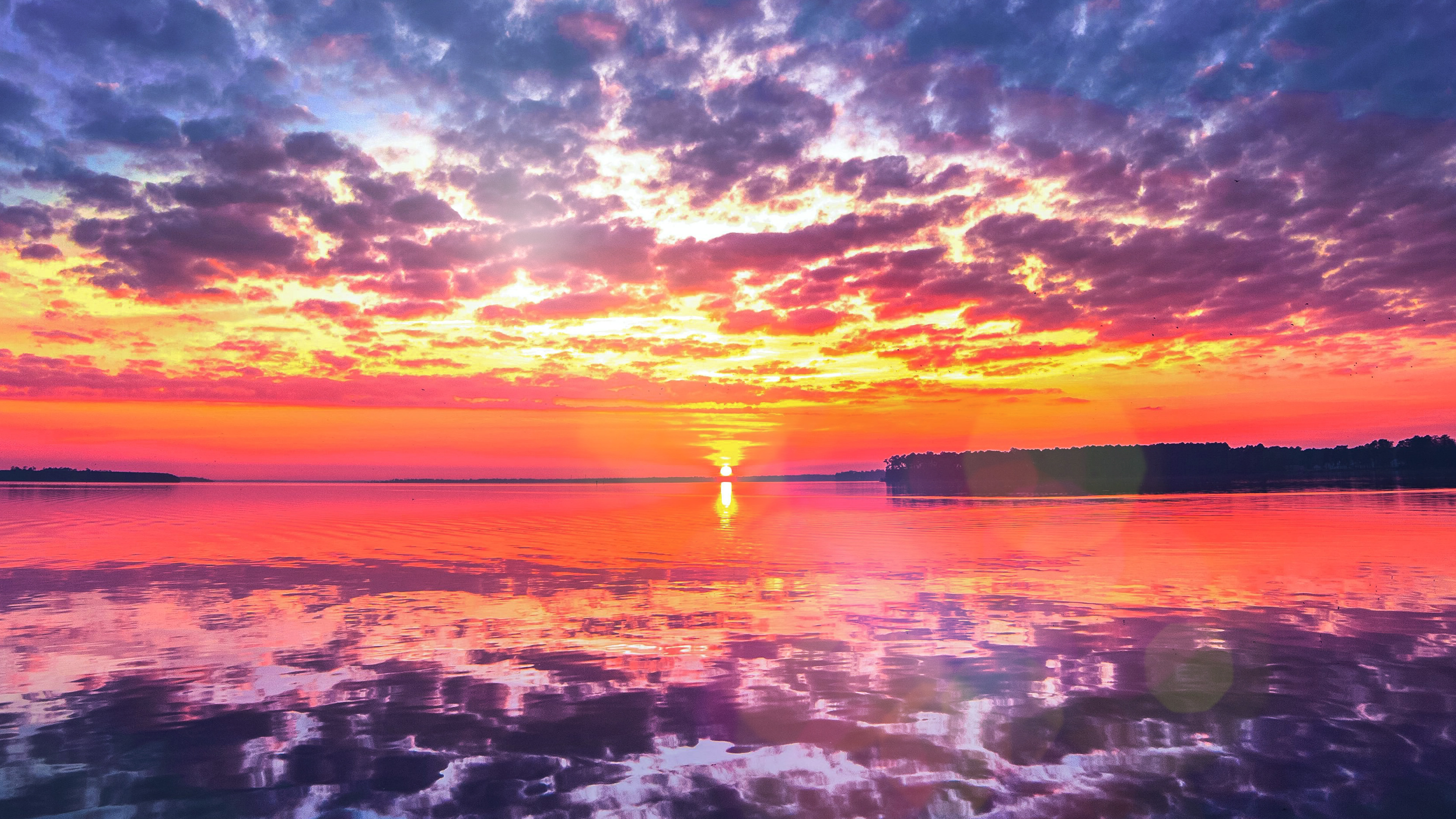 Vivid sunset horizon, Pink and purple clouds, Reflective water surface, 4K Desktop wallpaper