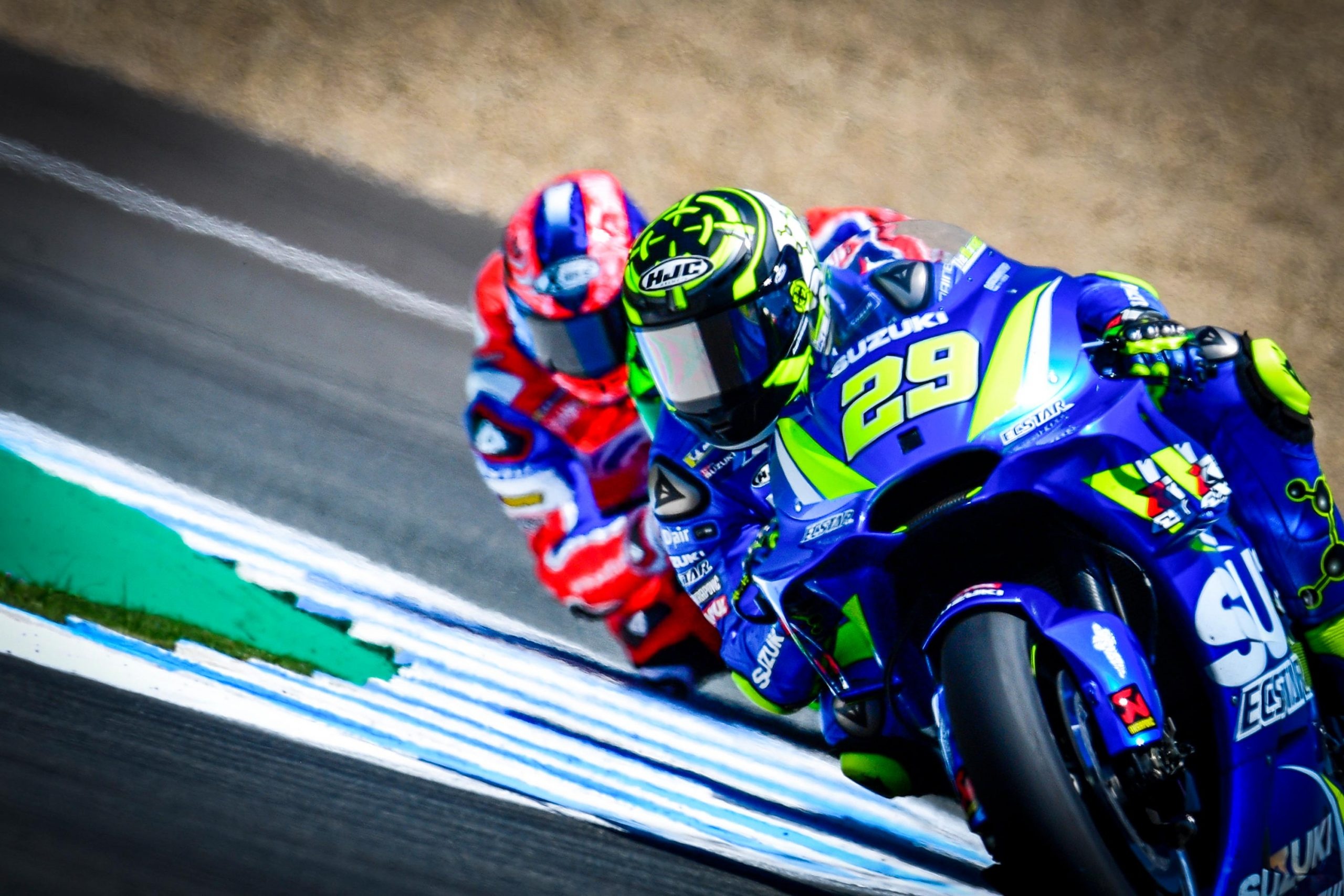 Andrea Iannone number 29, Suzuki Ecstar GSX-RR, Pramac Ducati chasing behind, MotoGP lean over blue kerb, HD Desktop wallpaper