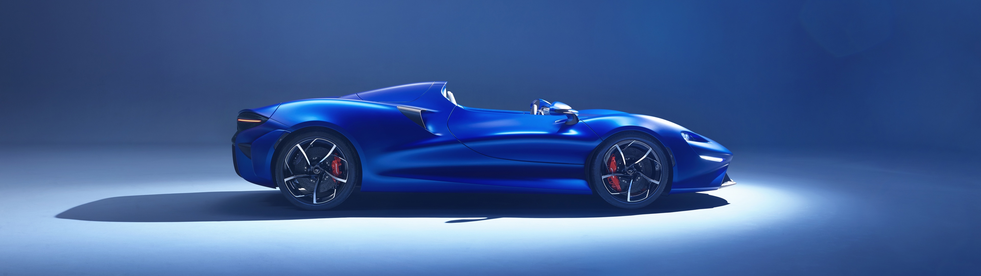 McLaren Elva, open-cockpit speedster, blue studio lighting, Dual Screen Desktop wallpaper