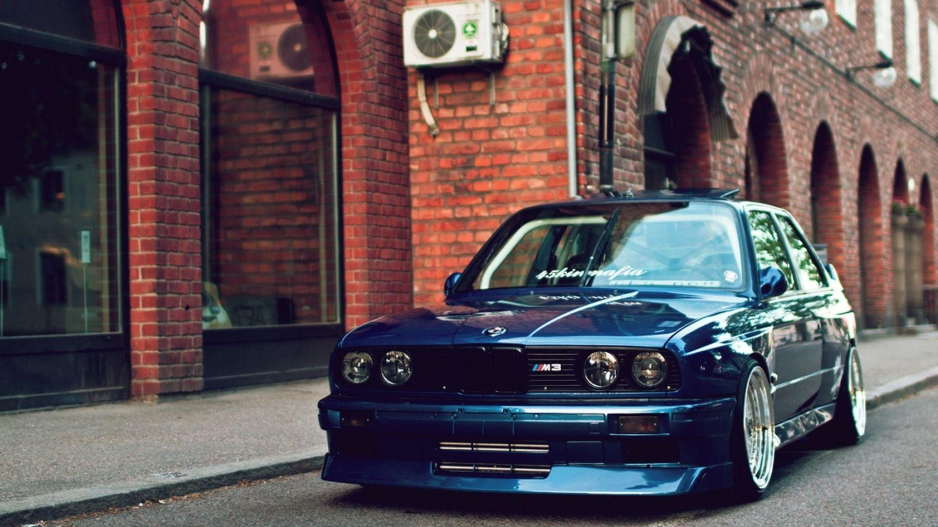 BMW M3 E30, red brick facade, deep dish alloy wheels, Full HD Desktop wallpaper