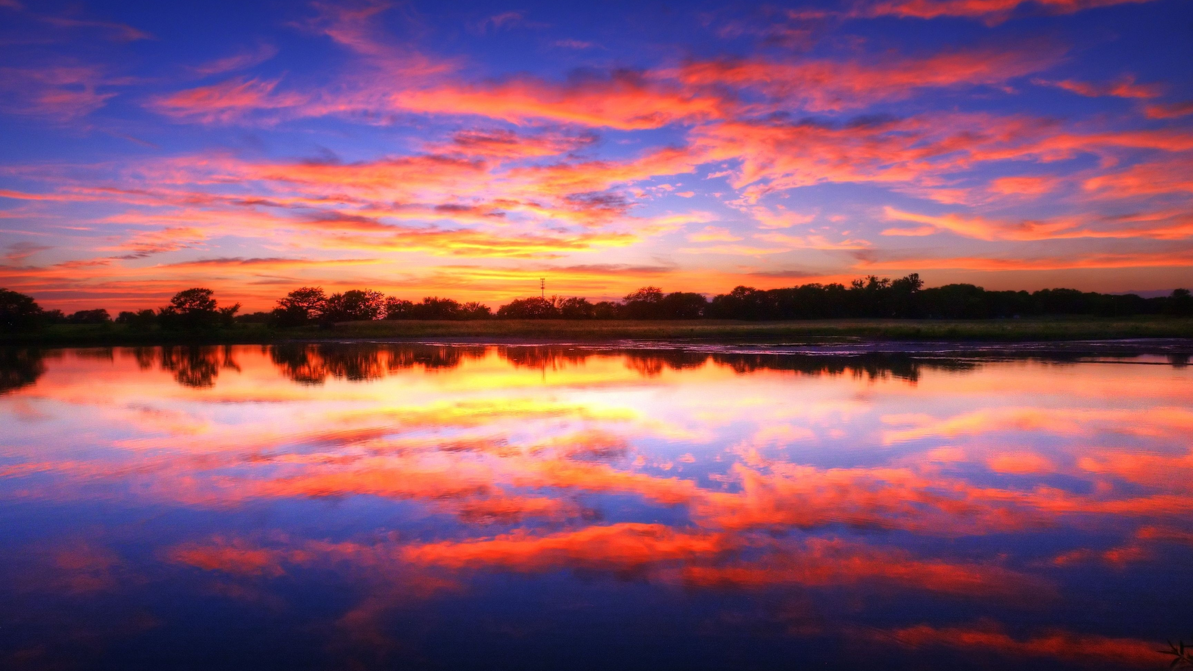 sunset cloud reflection, fiery dusk sky, silhouetted tree line, 4K Desktop wallpaper