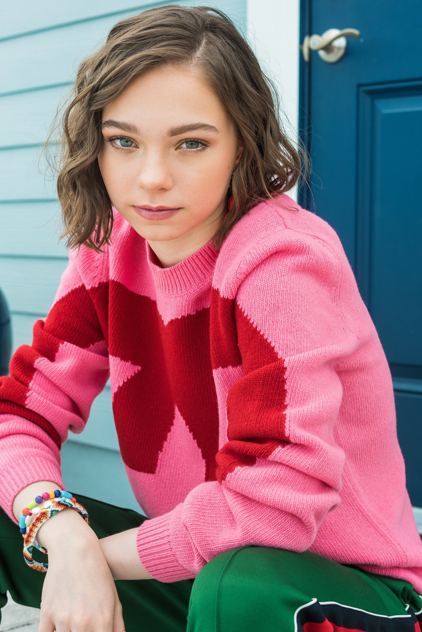 Emma Myers in star sweater, Pink and red knit sweater, Stacked beaded bracelets, Teal clapboard porch wall, HD Phone wallpaper