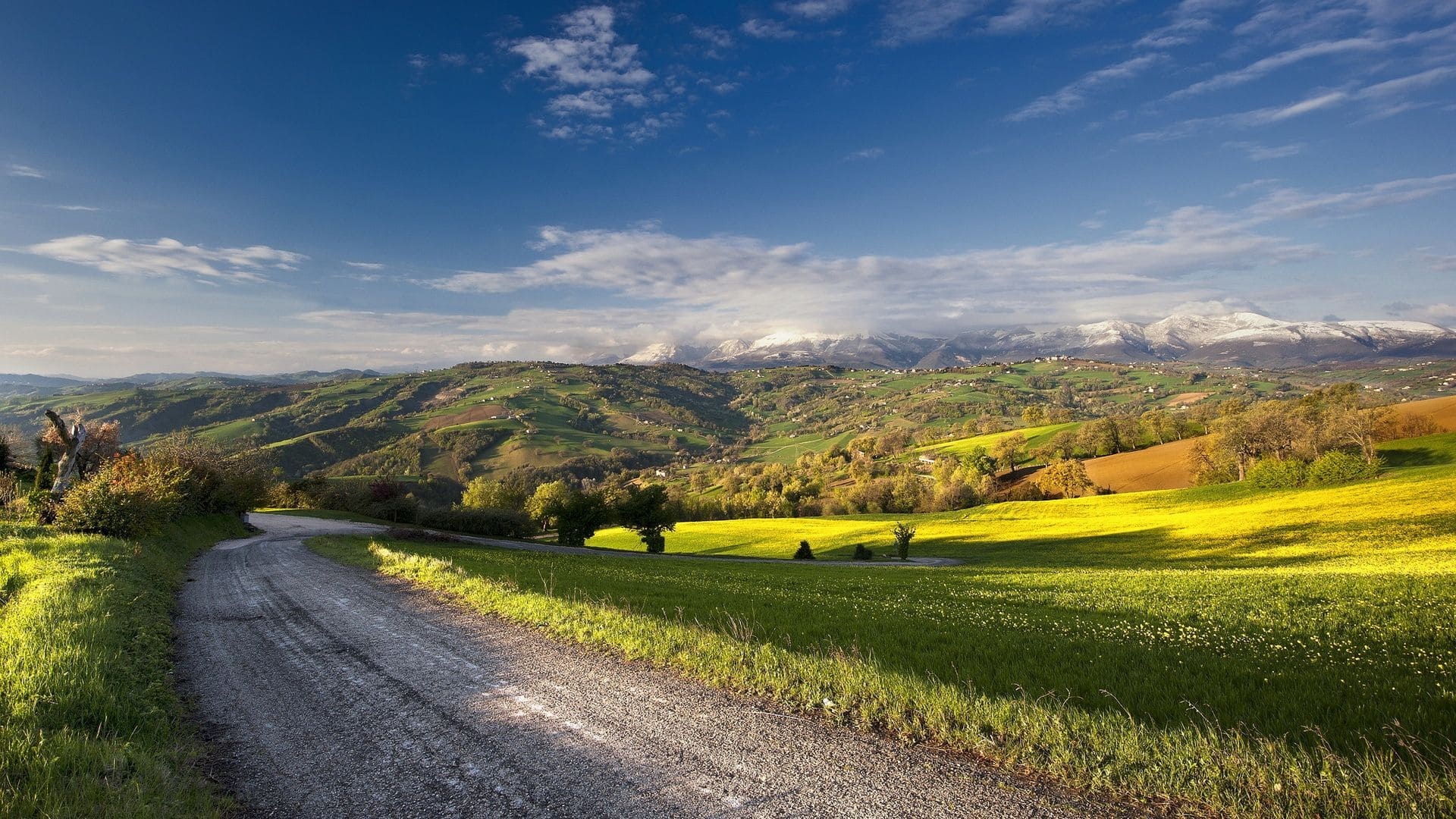 snow-capped mountain range, winding gravel country road, rolling green rural hills, Full HD Desktop wallpaper