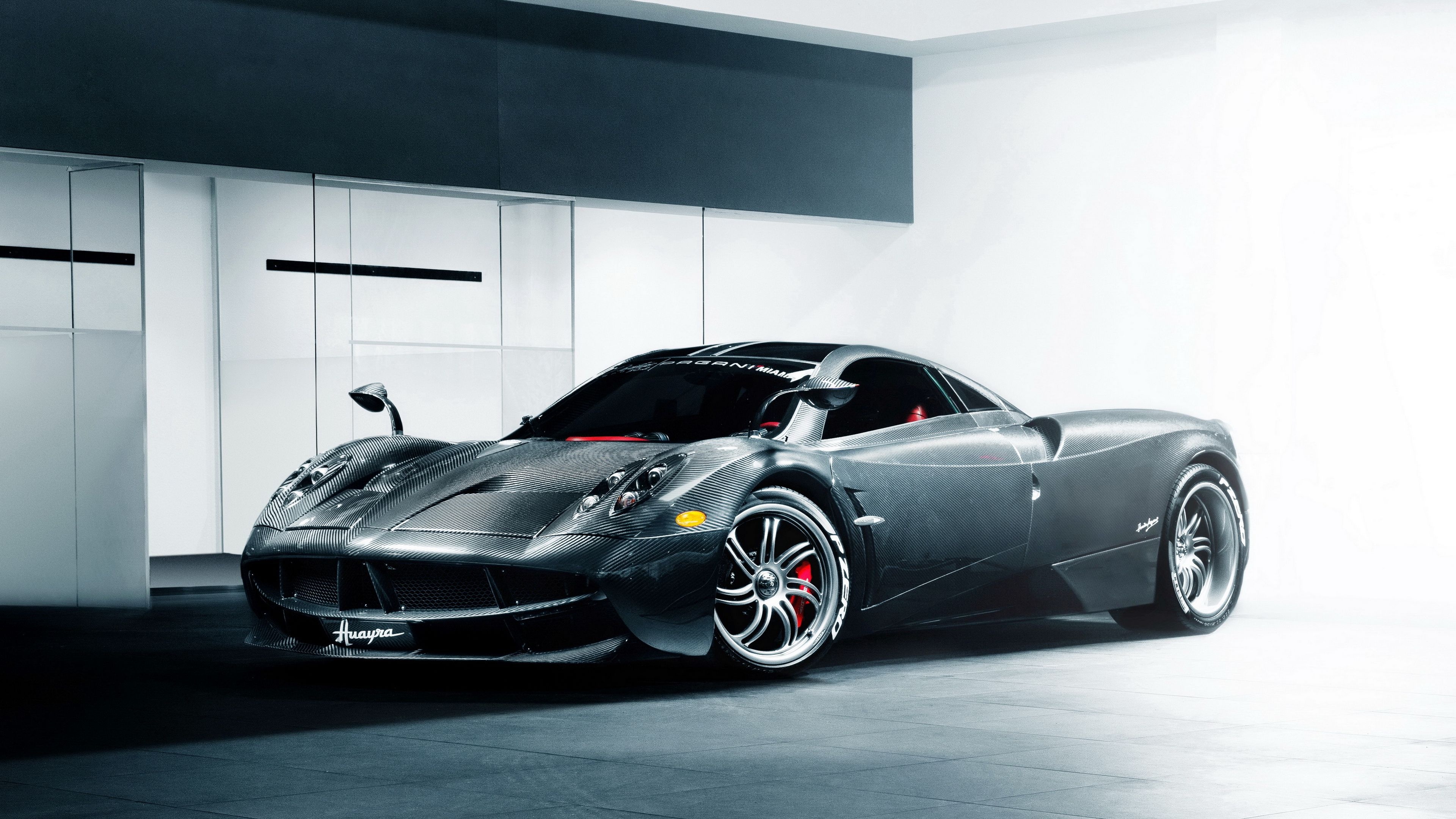 Pagani Huayra, exposed carbon fiber body, modern minimalist showroom, 4K Desktop wallpaper