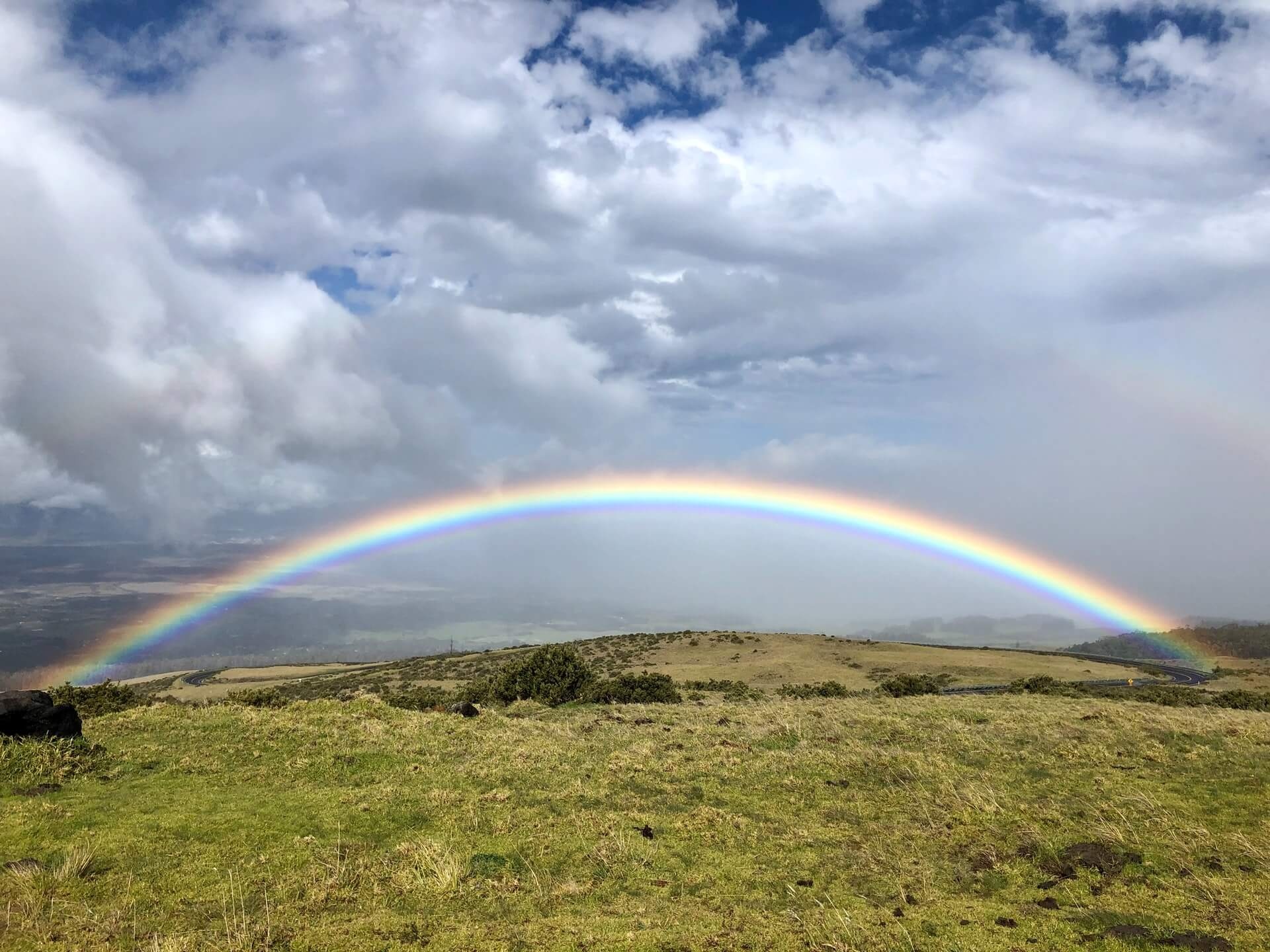 Vibrant low rainbow arc, Grassy hillside pasture, Scattered cumulus clouds, HD Desktop wallpaper
