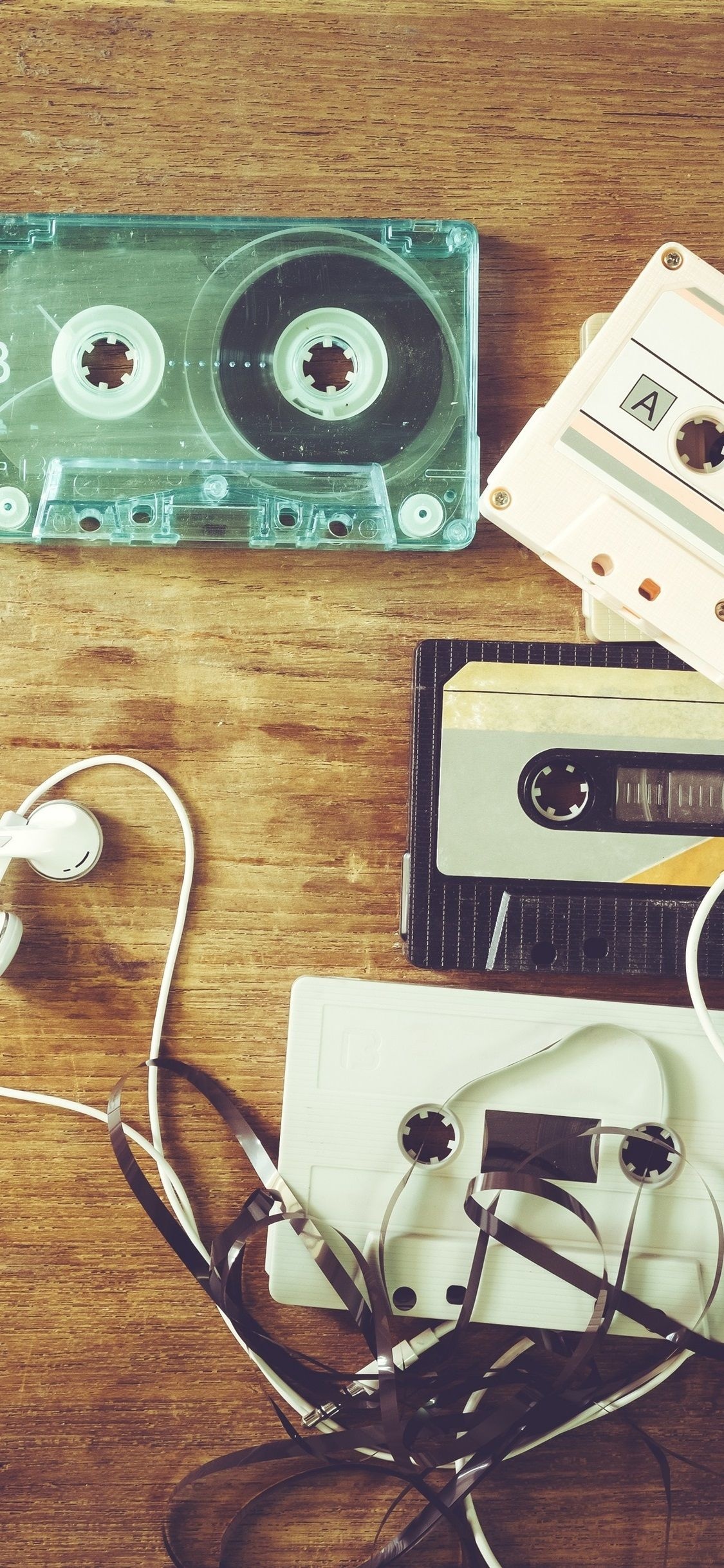 Tangled audio cassette tape, Vintage cassette tapes, White wired earphones, Rustic wooden tabletop, HD Phone wallpaper