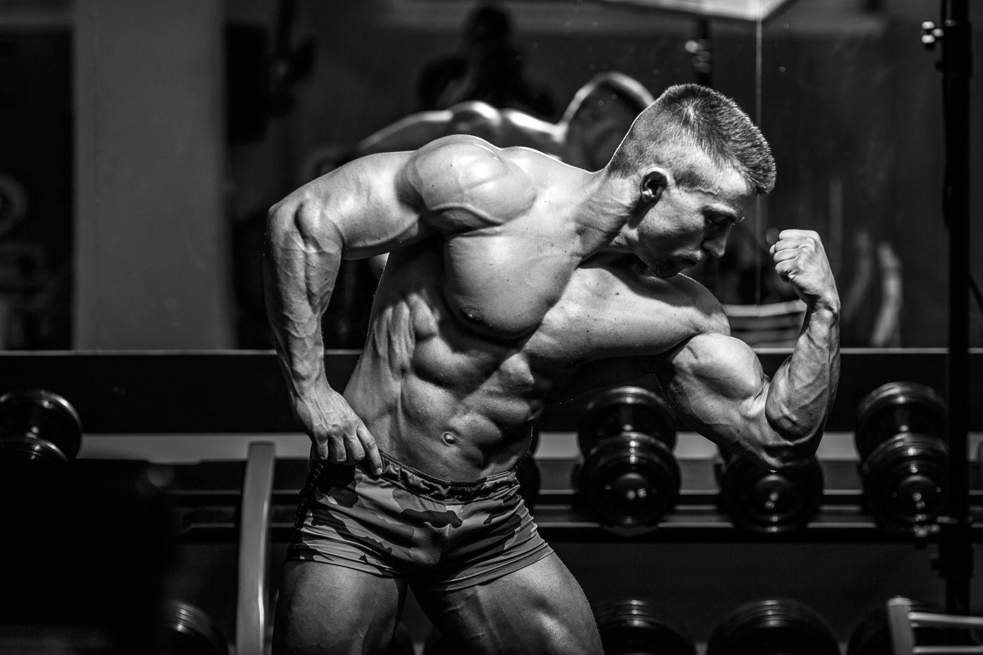 Flexing male bodybuilder, Gym dumbbell rack, Monochrome fitness photography, HD Desktop wallpaper