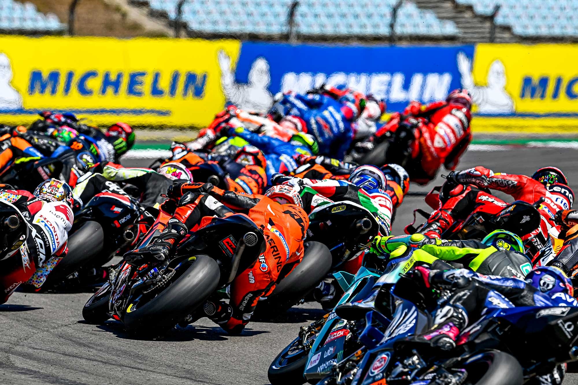 MotoGP pack at start, Orange KTM RC16 leaning, Riders stacked into corner, HD Desktop wallpaper