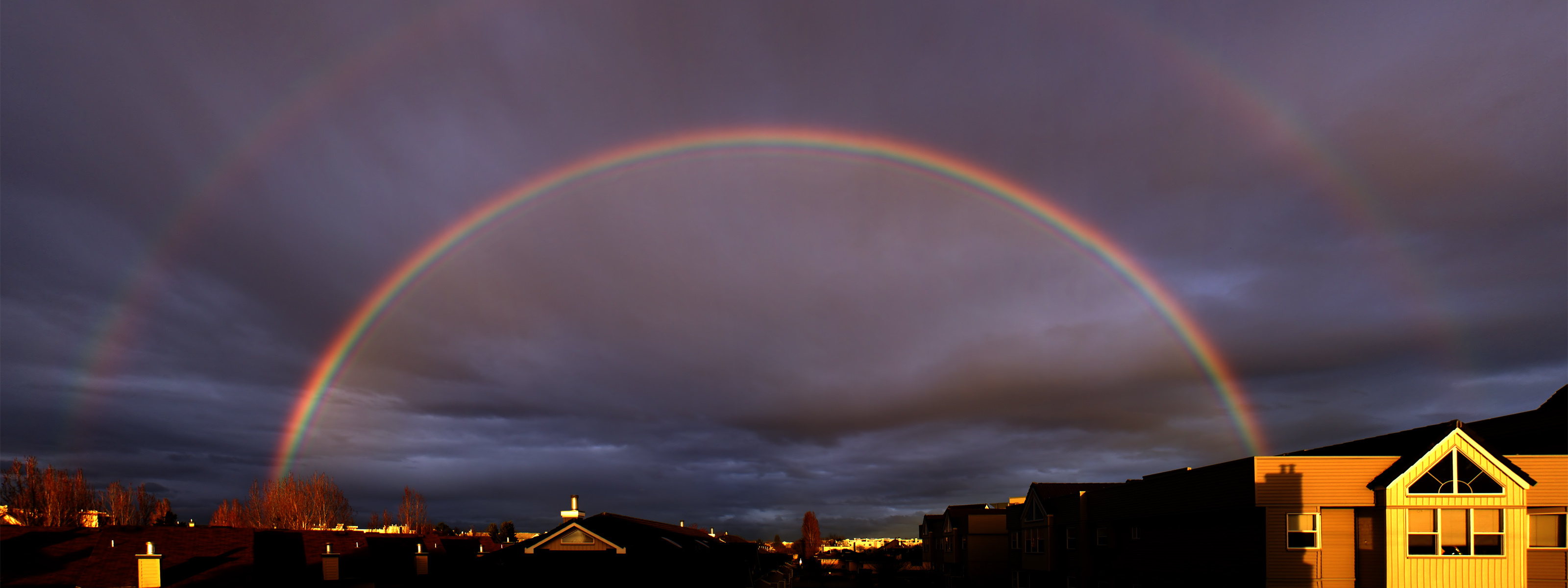 Full arch double rainbow, Dark stormy sky, Suburban house rooftops, Dual Screen Desktop wallpaper