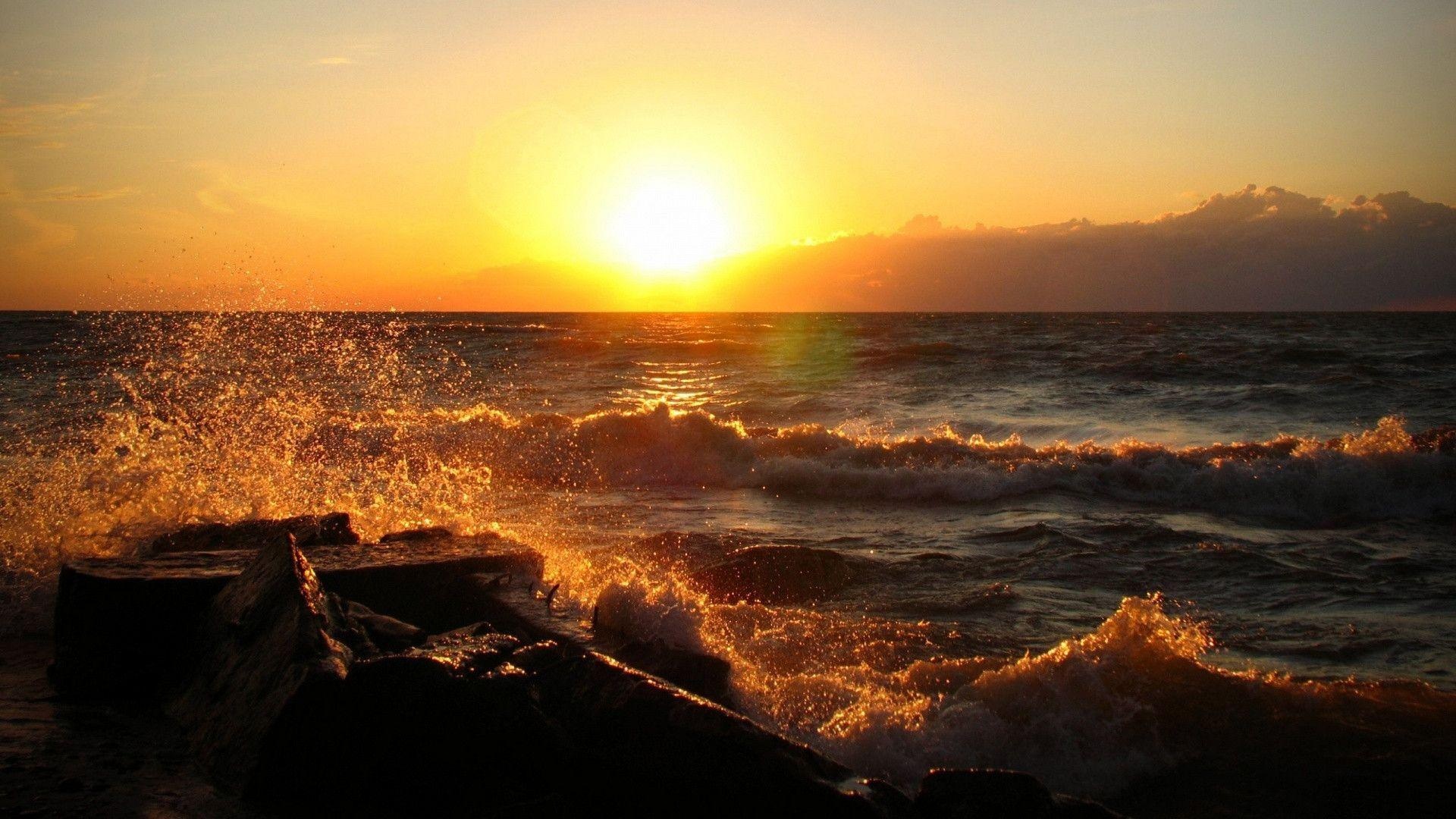 Glowing sunset over sea, Splashing golden sea spray, Rocky shoreline breaking waves, Full HD Desktop wallpaper