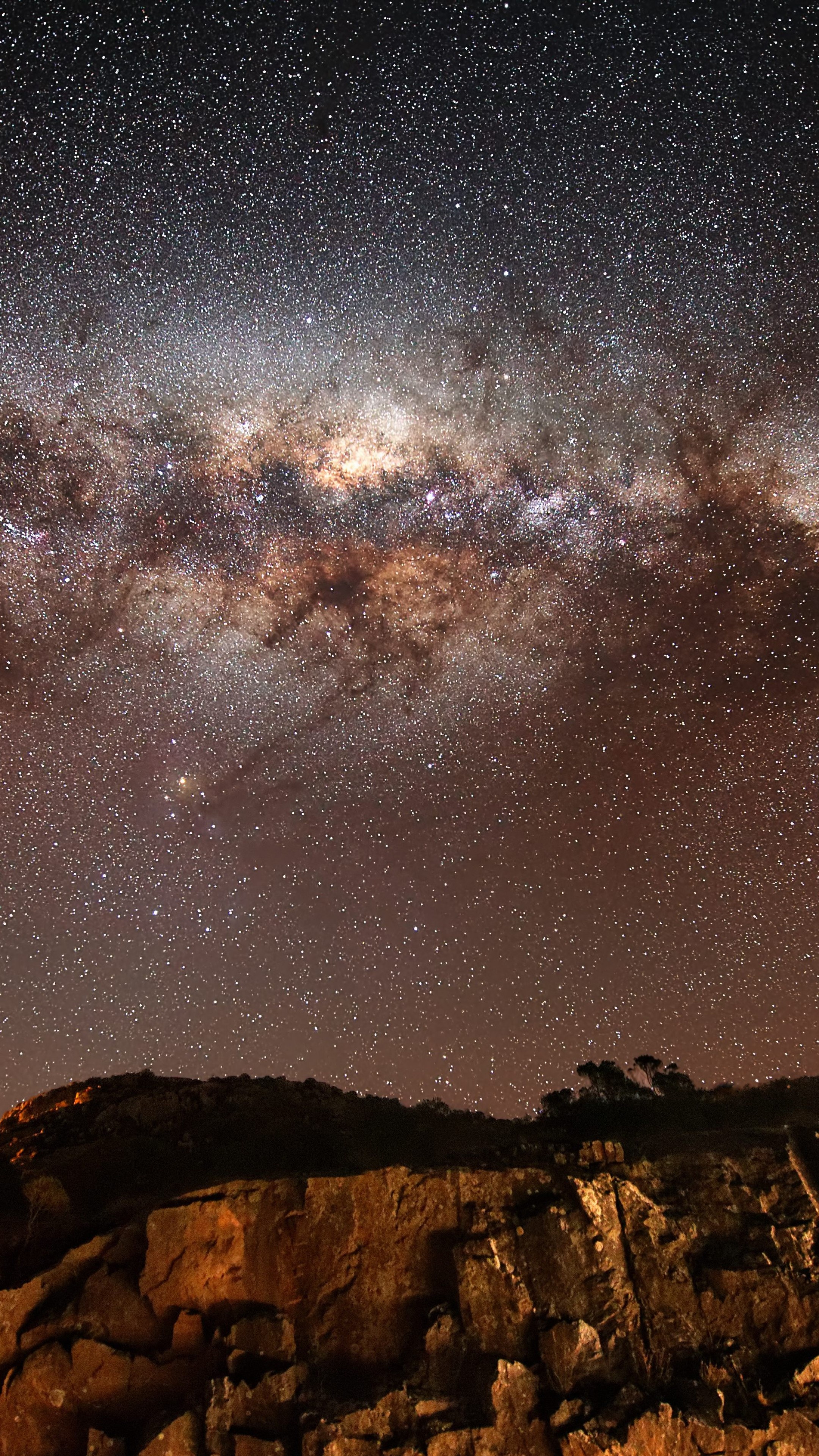 Milky Way galaxy core, illuminated rocky cliff, starry night sky, 4K Phone wallpaper