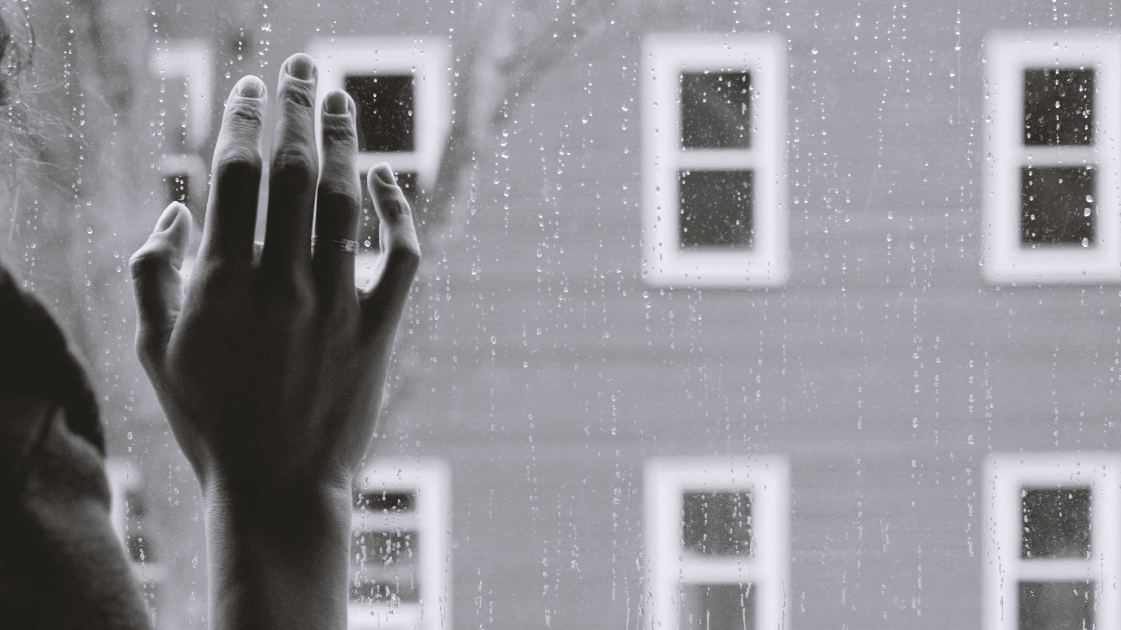 Hand on rain-streaked window, Raindrops on window glass, Monochrome apartment building facade, 4K Desktop wallpaper