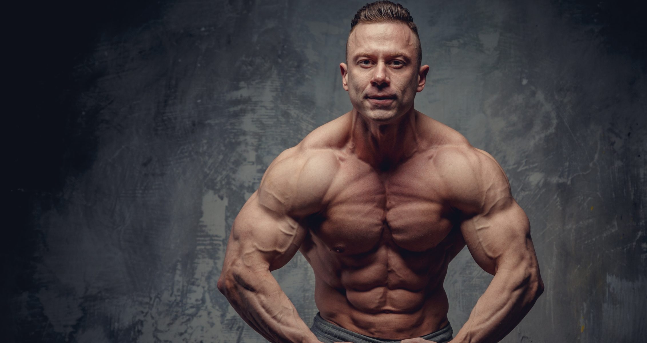 Muscular male bodybuilder, Defined pectoral muscles, Textured studio backdrop, HD Desktop wallpaper