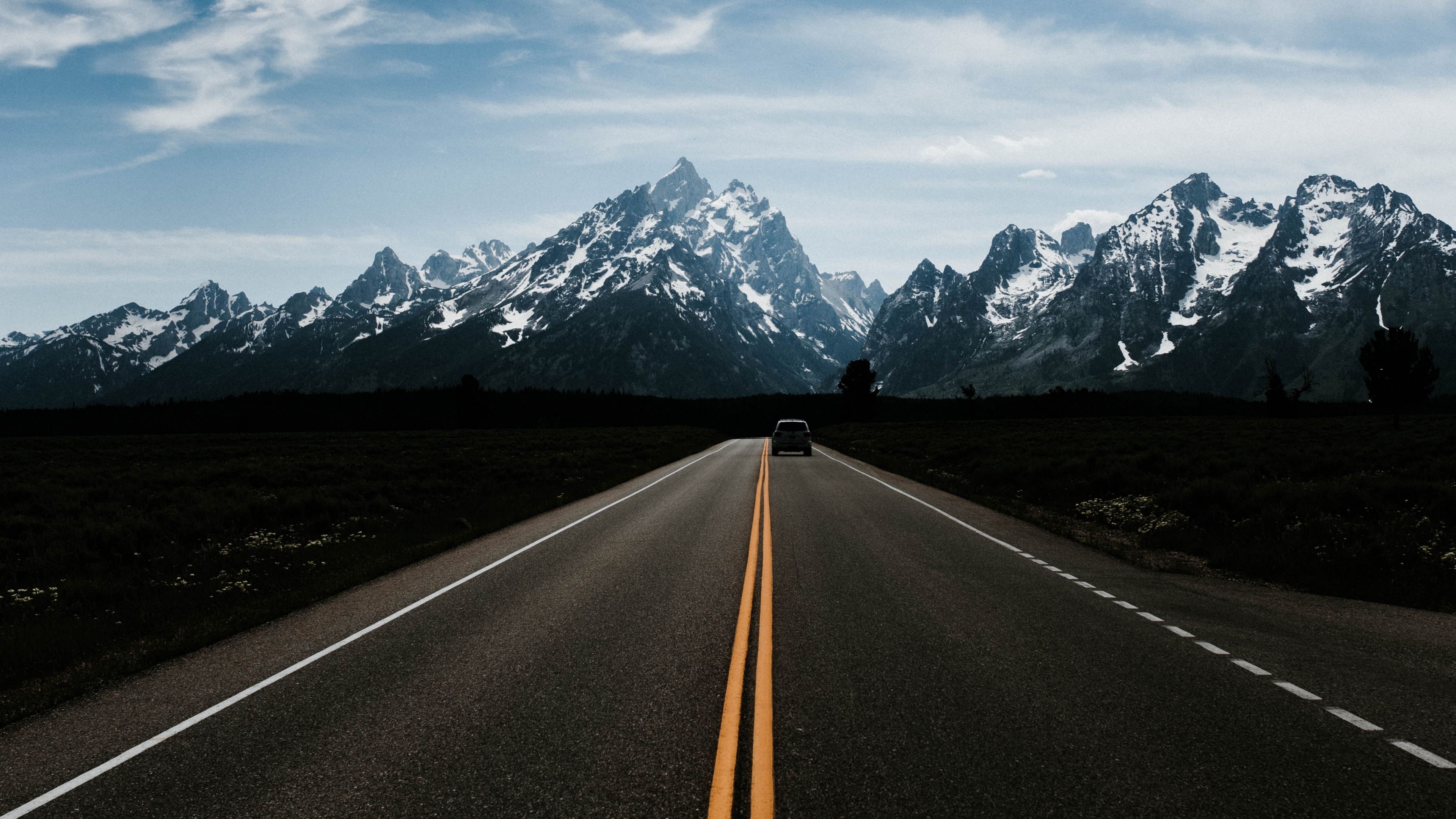 Teton Range, two-lane paved highway, distant dark SUV, 4K Desktop wallpaper