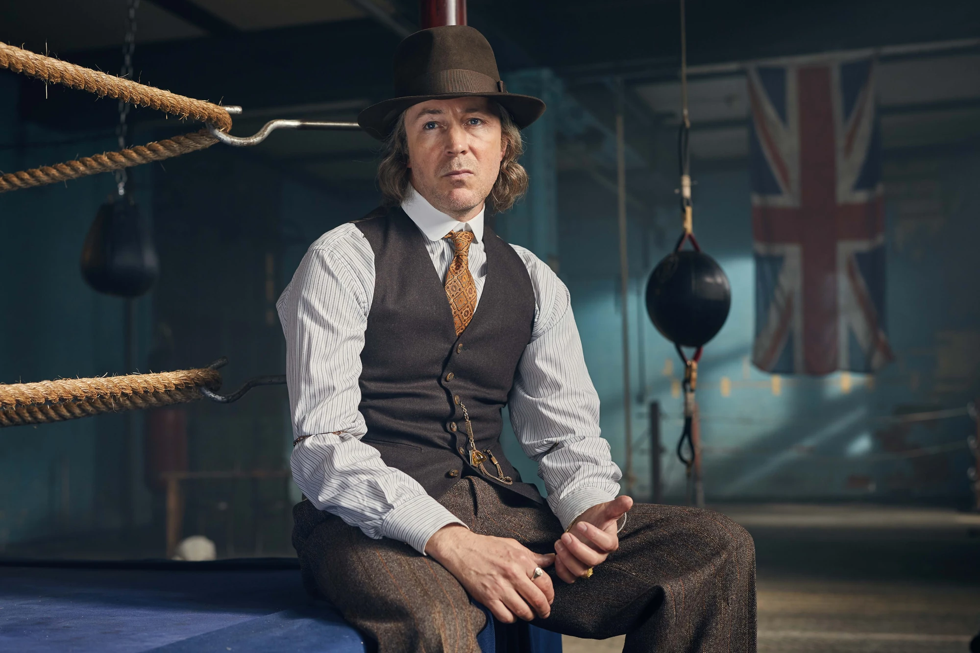 Aberama Gold (Aidan Gillen), Bowler hat and gold rings, Boxing gym ringside, Union Jack banner, HD Desktop wallpaper